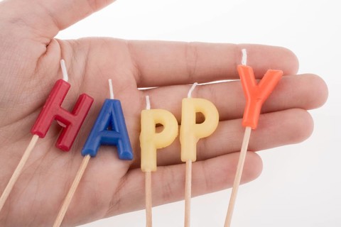Color candles on sticks write the word happy