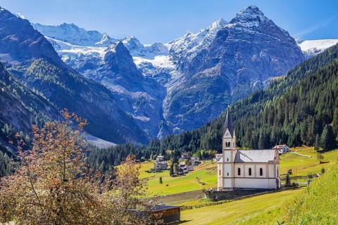 View of the village with the Church of the Visitation of the Virgin Mary and the Trafoier Ice Wall 3565m