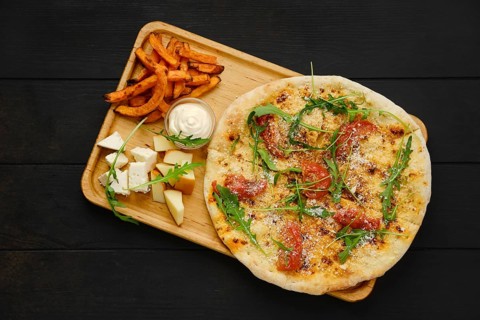 Top view of focaccia with tomato and parmesan served with cheese and fried sweet potato on wooden tray
