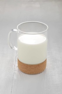 Glass of milk on white wooden kitchen table