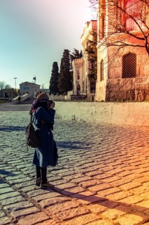 Tourist girl photographer with dslr camera outdoor in city street