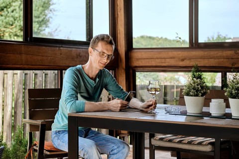 Smiling man wearing glasses using phone