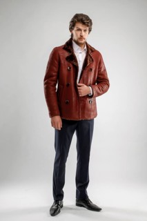 Brutal handsome unshaven man with beard and moustache in sheepskin coat with fur collar