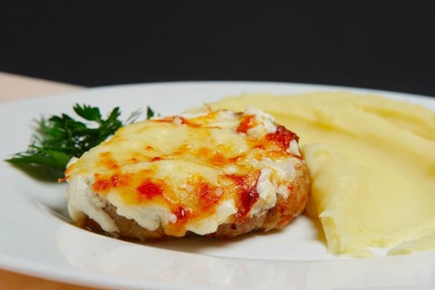 Meat cutlet with cheese and mashed potato. Closeup photo with selective focus