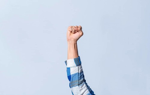 Hand gesturing the letter S in sign language on an isolated background. Man's hand gesturing the letter S of the alphabet isolated. Letter S of the alphabet in sign language
