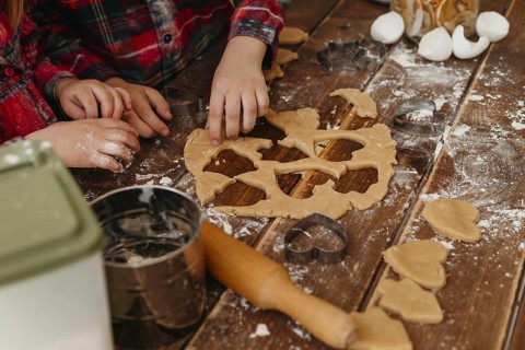 High angle children making cookies together home