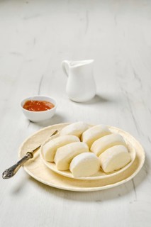 Closeup view of semifinished frozen lazy dumplings made of curd on a plate