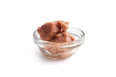 Canned tuna in transparent plate isolated on white