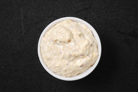 Overhead view of small bowl with caesar sauce for salad