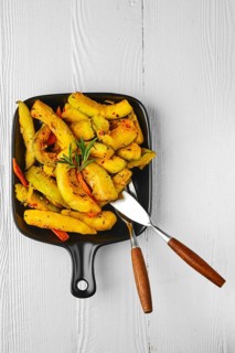 Top view of spicy pumpkin and carrot baked in oven on ceramic plate