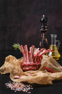 Rolled and tighted raw fresh rack of lamb in wrapping paper