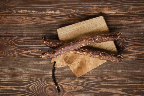 Sun dried turkey sausages on wooden background