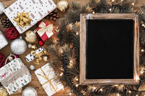 Photo frame fir twigs fairy lights near christmas decorations