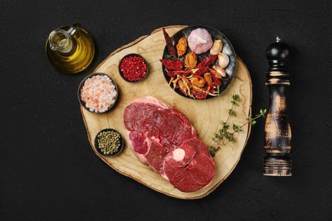 Top view of raw fresh lamb center cut leg steak with spice on wooden slab