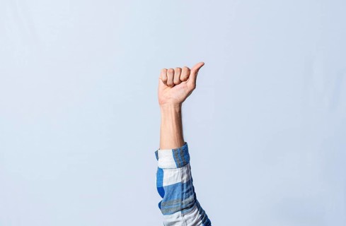 Hand gesturing the letter A in sign language on isolated background. Man hand gesturing the letter A of the alphabet isolated. Letters of the alphabet in sign language