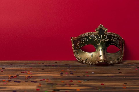 Carnival mask near red wall