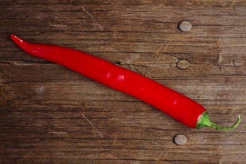 Top view of chili pepper on wooden background