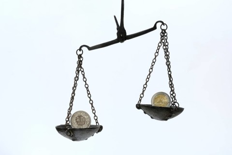 Weighing pan with francs and euro coins