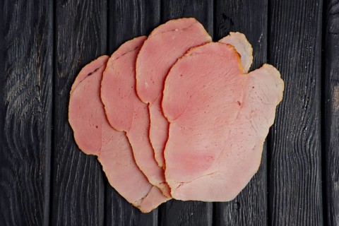 Top view of slices of fresh ham on wooden table