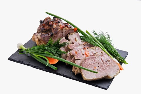 Baked ham decorated with fresh vegetables isolated on white background