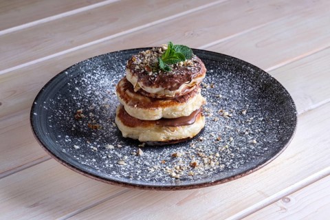 Fritters with peanut butter. Traditional Slavic pancakes with chocolate paste