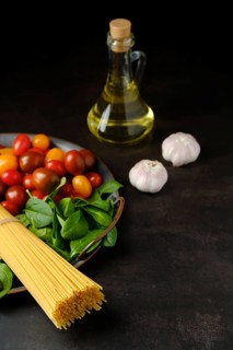 Low key photo of bunch of raw spaghetti with spinach