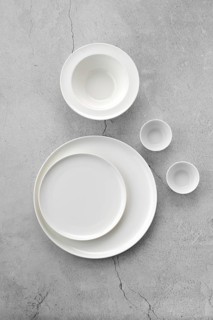 Overhead view of white tableware on grey background