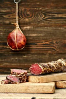 Smoked dried beef meat cut on slices on wooden cutting board