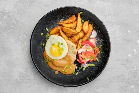 Top view of chopped pork sirloin with fried potato wedges