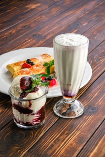Plate with thin pancakes stuffed with curd and served with berry jam