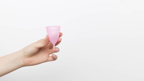 Close up hand holding menstrual cup
