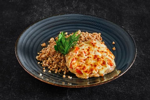 Chopped pork meat baked with cheese and tomato served with buckwheat porridge