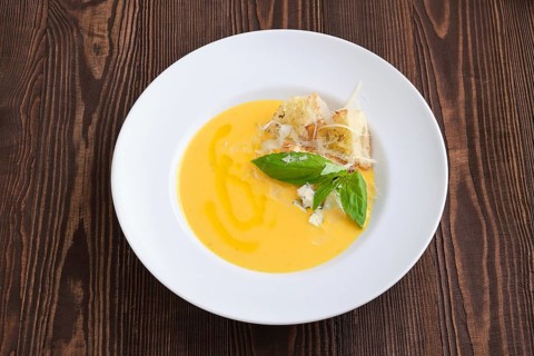 Top view of cheese soup with blue cheese and crouton on dark wooden background