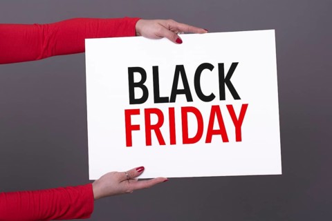 Female hands holding a black friday poster. Studio shot