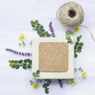 Cork frame with twig flowers string spool wooden textured backdrop