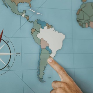 Person pointing south america map