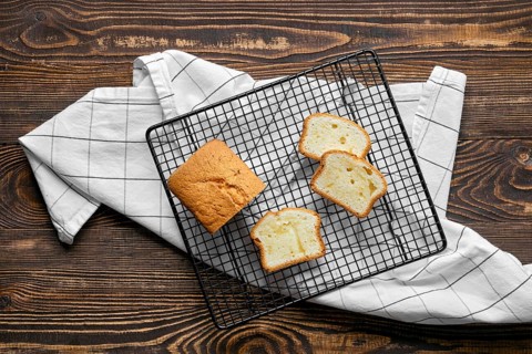 Overhead view of fresh biscuit cake with apple on wooden table