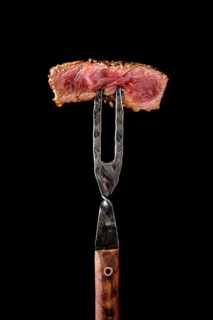 Piece of medium rare steak on the fork