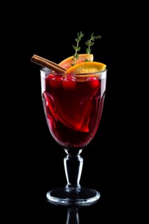 Glass of hot mulled wine isolated on black.