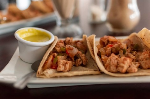 Delicious Mexican chicken tacos with salsa and pico de gallo served on the table