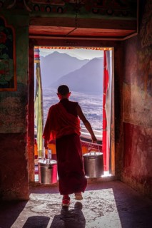 A young monk going through a door at Thiksey Monastery