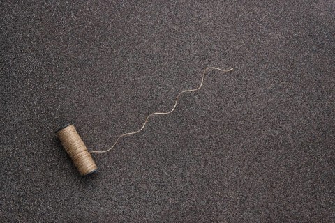 Top view of untwisted linen twine on dark stone background
