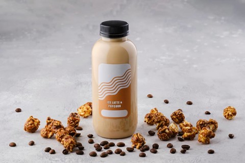 Small bottle with ice latte and popcorn cocktail on the table