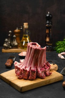 Closeup view of raw lamb ribs rolled in the shape of crown on the table