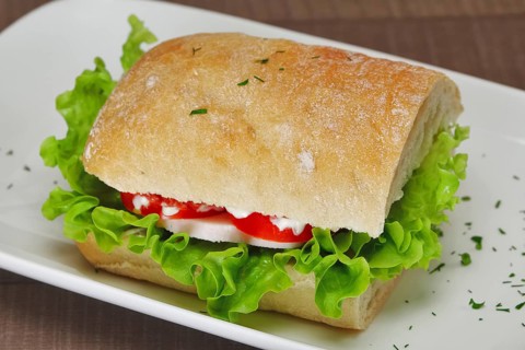 Ciabatta panini sandwich with chicken and tomato. Sandwich stuffed with sausage