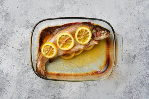 Top view of trout baked in oven in glass baking dish