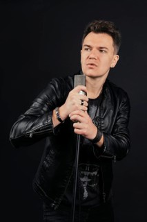 Low key portrait of man singing and holding microphone