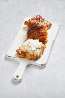 Various croissants on white serving board on marble background