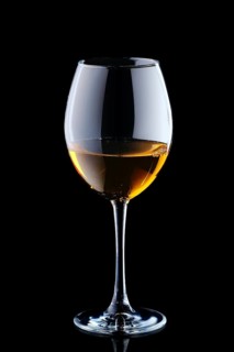 Glass with white wine isolated on black background