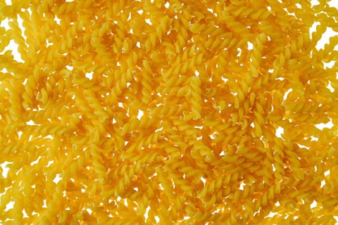 Top view of fusilli pasta scattered on white